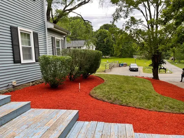Fresh red mulch bed beside deck